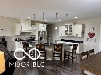 217 N Liberty Blvd, Mooresville, IN 46158 - kitchen featuring stainless steel fridge with ice dispenser, dark countertops, dark wood-style floors, a kitchen breakfast bar, and recessed lighting