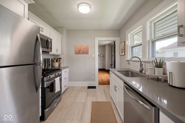 536 S 27th St, Lafayette, IN 47904 - kitchen featuring stainless steel appliances, a sink, backsplash, white cabinets, and baseboards