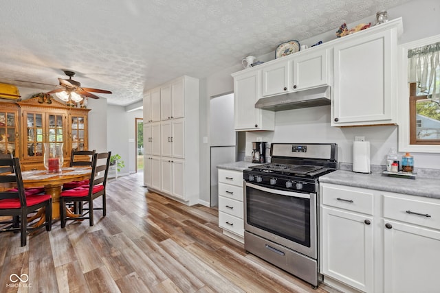 7441 State Road 60 W, Mitchell, IN 47446 - kitchen featuring stainless steel gas range, under cabinet range hood, a textured ceiling, light countertops, and ceiling fan