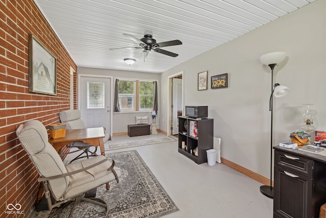 7441 State Road 60 W, Mitchell, IN 47446 - sitting room with finished concrete flooring, brick wall, an office area, baseboards, and a ceiling fan