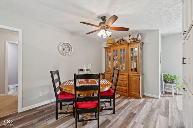 7441 State Road 60 W, Mitchell, IN 47446 - dining area with a ceiling fan, light wood finished floors, a textured ceiling, and baseboards