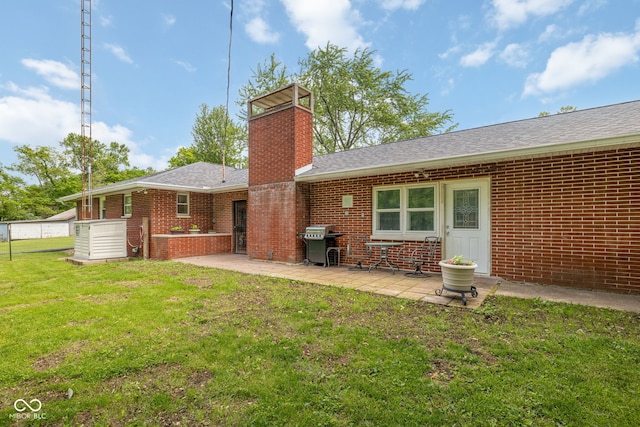 7441 State Road 60 W, Mitchell, IN 47446 - back of property featuring a patio, a lawn, a chimney, brick siding, and roof with shingles