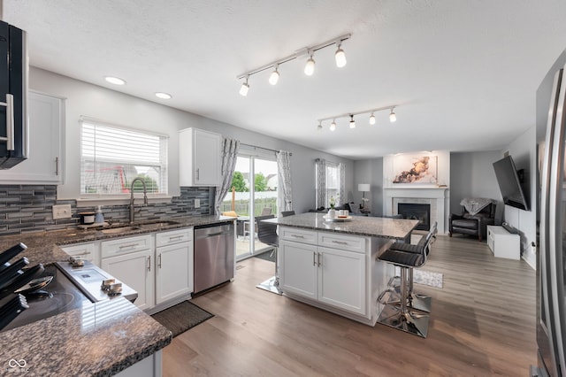 3638 Fieldstone Ln, Plainfield, IN 46168 - kitchen with a sink, appliances with stainless steel finishes, a kitchen bar, a kitchen island, and backsplash