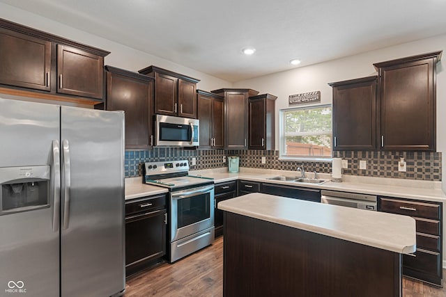 918 Cass Dr, Franklin, IN 46131 - kitchen featuring appliances with stainless steel finishes, a sink, dark wood finished floors, dark brown cabinetry, and decorative backsplash