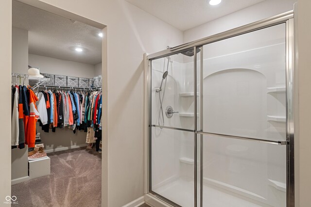 918 Cass Dr, Franklin, IN 46131 - bathroom featuring a stall shower, a walk in closet, recessed lighting, and baseboards