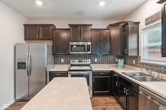 918 Cass Dr, Franklin, IN 46131 - kitchen with appliances with stainless steel finishes, a sink, light countertops, wood finished floors, and tasteful backsplash