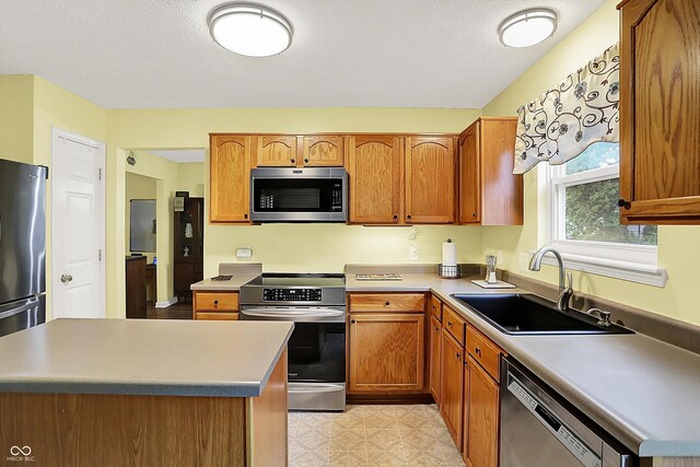 2623 Senators Way, Indianapolis, IN 46217 - kitchen with appliances with stainless steel finishes, a sink, brown cabinetry, and light floors