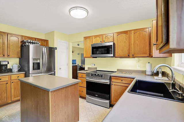 2623 Senators Way, Indianapolis, IN 46217 - kitchen with appliances with stainless steel finishes, light flooring, a sink, light countertops, and a kitchen island