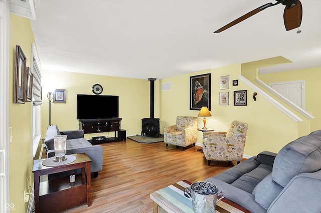 2623 Senators Way, Indianapolis, IN 46217 - living room featuring ceiling fan, wood finished floors, a wood stove, and stairway