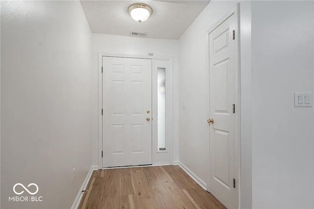 6707 Dovir Woods Dr, Sellersburg, IN 47172 - entryway with light wood finished floors, baseboards, and a textured ceiling