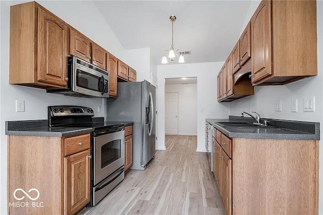 6707 Dovir Woods Dr, Sellersburg, IN 47172 - kitchen with stainless steel appliances, a sink, dark countertops, and light wood-type flooring