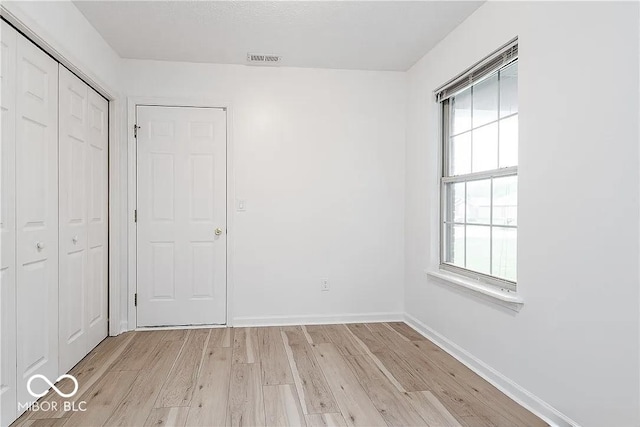 6707 Dovir Woods Dr, Sellersburg, IN 47172 - unfurnished bedroom with light wood-type flooring, multiple windows, a closet, and baseboards