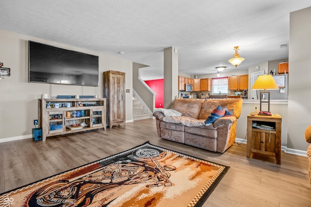 2730 Foxbriar Pl, Indianapolis, IN 46203 - living area with stairs, light wood-style floors, baseboards, and a textured ceiling