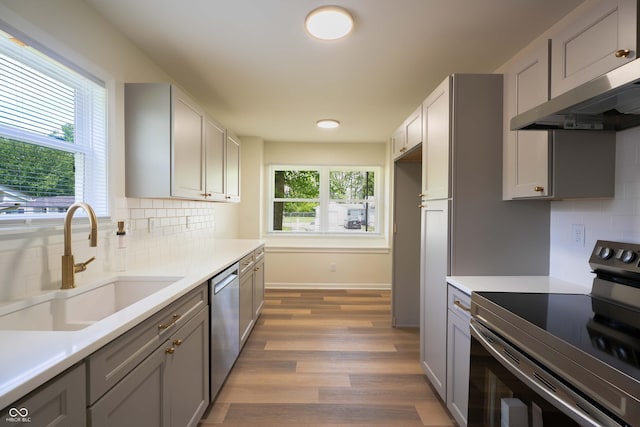 2721 W 34th St, Anderson, IN 46011 - kitchen with stainless steel appliances, a sink, gray cabinetry, wood finished floors, and light countertops