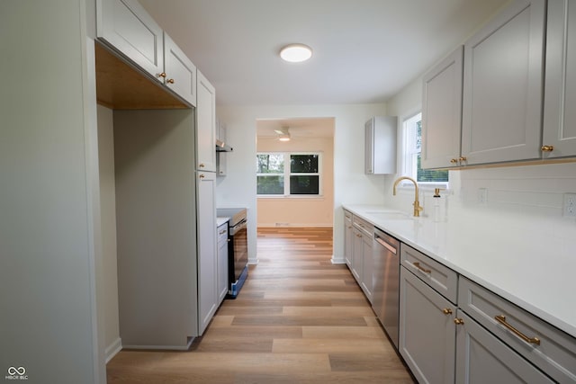 2721 W 34th St, Anderson, IN 46011 - kitchen with appliances with stainless steel finishes, a sink, light wood-type flooring, gray cabinetry, and decorative backsplash