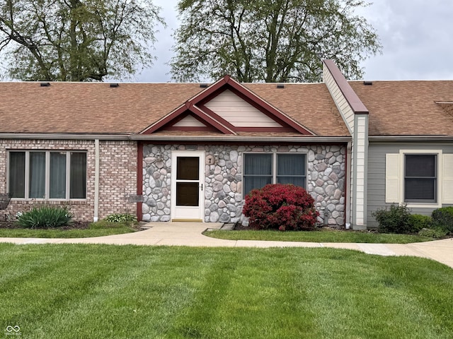 1711 Lafayette Ave Unit 7, Lebanon, IN 46052 - view of front facade featuring roof with shingles, a front yard, and stone siding