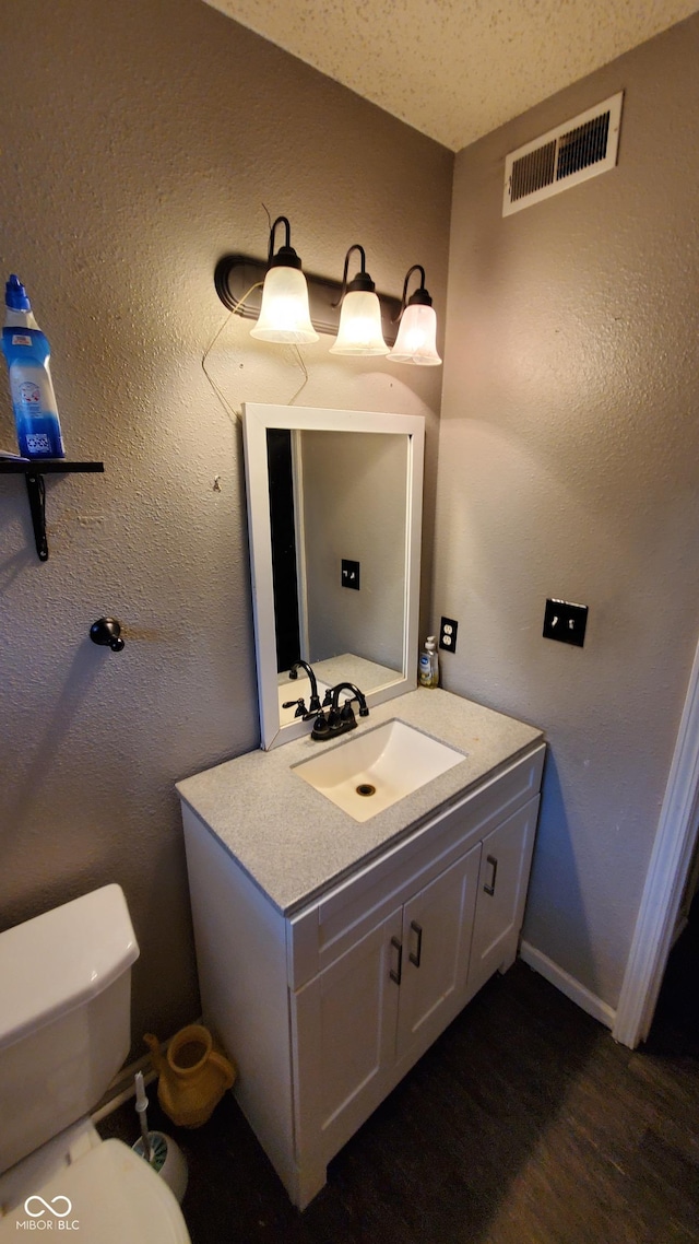6637 Larkwood Ct, Indianapolis, IN 46241 - bathroom with vanity, toilet, wood finished floors, and baseboards