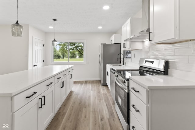 8933 W 1050 S, Fortville, IN 46040 - kitchen featuring stainless steel appliances, wall chimney exhaust hood, light wood finished floors, recessed lighting, and white cabinets
