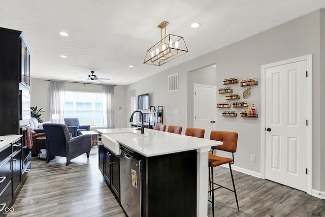 158 Handley St, Indianapolis, IN 46222 - kitchen featuring a sink, a kitchen bar, dark cabinetry, light countertops, and dishwasher
