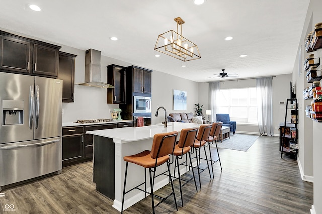 158 Handley St, Indianapolis, IN 46222 - kitchen featuring appliances with stainless steel finishes, wall chimney range hood, open floor plan, dark wood finished floors, and a breakfast bar
