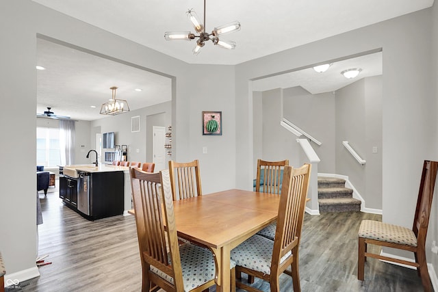 158 Handley St, Indianapolis, IN 46222 - dining space with light wood-style floors, a ceiling fan, a chandelier, stairs, and baseboards
