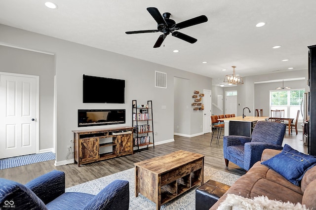 158 Handley St, Indianapolis, IN 46222 - living room with recessed lighting, wood finished floors, baseboards, a ceiling fan, and a chandelier