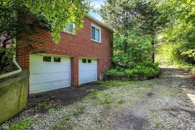 3215 E Edgewood Ave, Indianapolis, IN 46227 - view of side of home featuring brick siding, a garage, and asphalt driveway