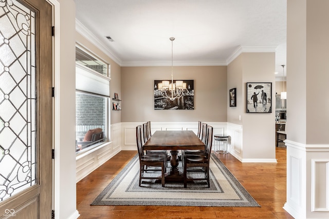 3335 Guilford Ln, Plainfield, IN 46168 - dining space with wood finished floors, a chandelier, crown molding, and wainscoting
