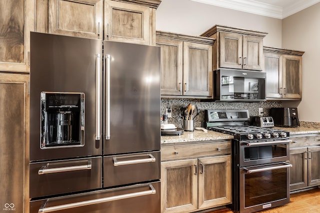 3335 Guilford Ln, Plainfield, IN 46168 - kitchen featuring appliances with stainless steel finishes, ornamental molding, decorative backsplash, light stone counters, and light wood-style flooring