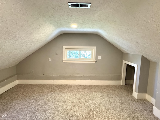 4814 E New York St, Indianapolis, IN 46201 - bonus room featuring carpet floors, a textured ceiling, lofted ceiling, and baseboards