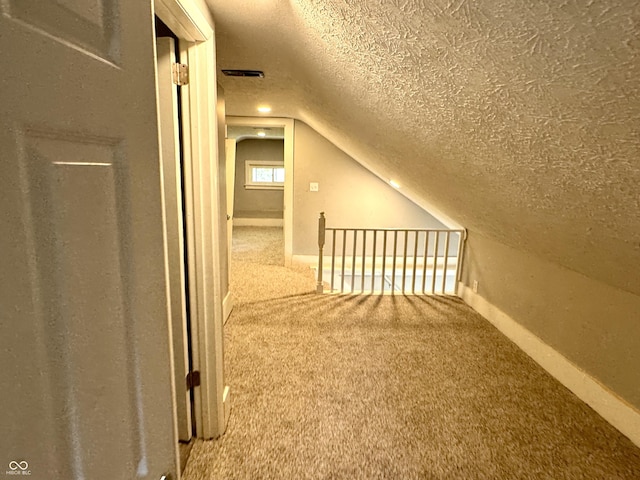 4814 E New York St, Indianapolis, IN 46201 - bonus room with carpet flooring, a textured ceiling, lofted ceiling, and baseboards