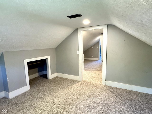 4814 E New York St, Indianapolis, IN 46201 - additional living space featuring carpet floors, a textured ceiling, baseboards, and lofted ceiling