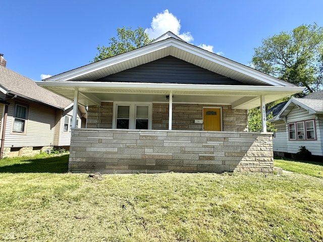 4814 E New York St, Indianapolis, IN 46201 - view of front of property with stone siding, a front lawn, and a porch