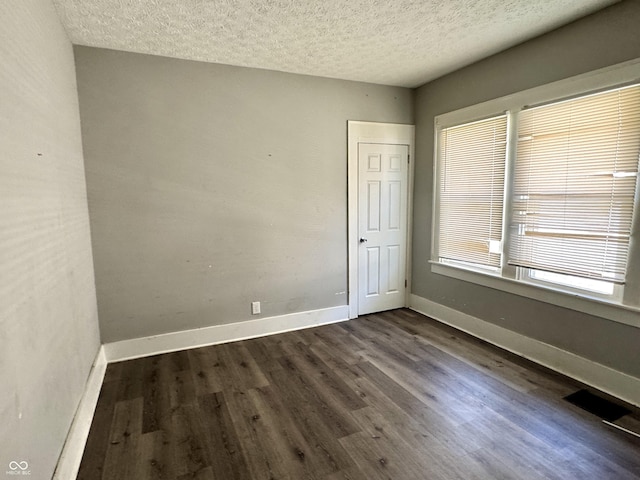 4814 E New York St, Indianapolis, IN 46201 - empty room featuring dark wood-style floors, a textured ceiling, and baseboards