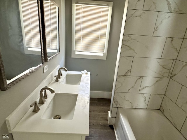 4814 E New York St, Indianapolis, IN 46201 - full bathroom with double vanity, wood finished floors, shower / washtub combination, and baseboards