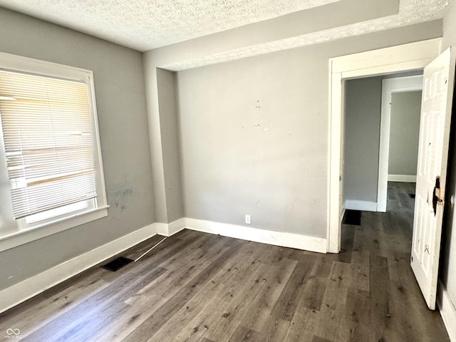 4814 E New York St, Indianapolis, IN 46201 - unfurnished room featuring a textured ceiling, dark wood-style flooring, and baseboards