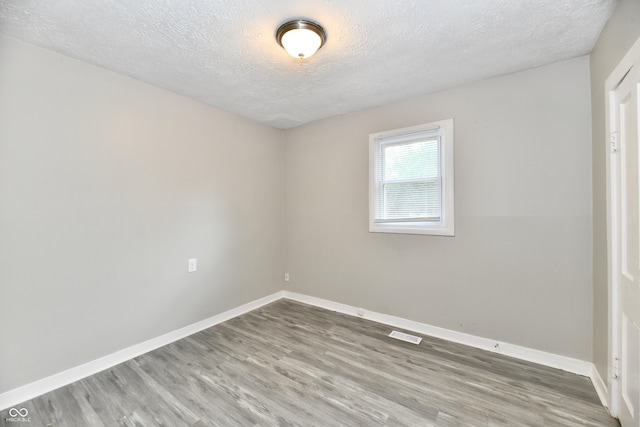 1730 N Graham Ave, Indianapolis, IN 46218 - empty room with a textured ceiling, wood finished floors, and baseboards