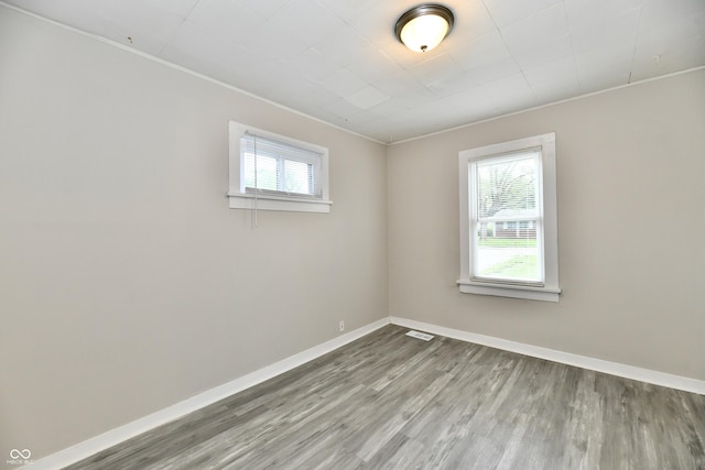 1730 N Graham Ave, Indianapolis, IN 46218 - unfurnished room featuring healthy amount of natural light, wood finished floors, baseboards, and crown molding