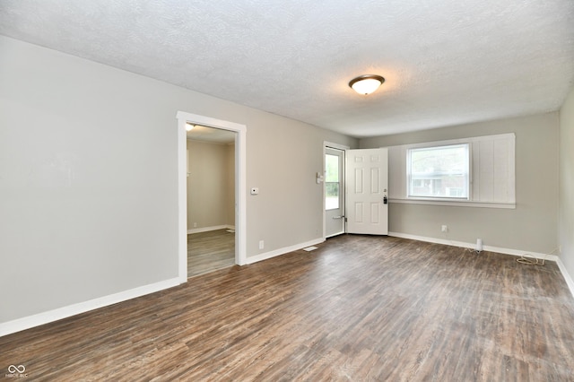 1730 N Graham Ave, Indianapolis, IN 46218 - empty room with dark wood-style floors, baseboards, and a textured ceiling
