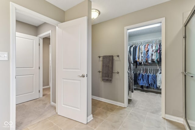 11844 Pine Meadow Cir, Fishers, IN 46037 - full bathroom featuring a spacious closet, tile patterned floors, a shower with door, and baseboards