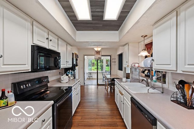 813 Boulder Rd, Indianapolis, IN 46217 - kitchen featuring black appliances, a tray ceiling, white cabinets, and light countertops