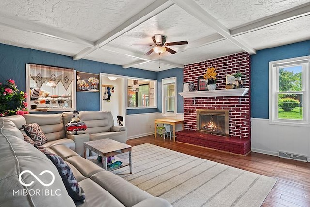 813 Boulder Rd, Indianapolis, IN 46217 - living area with a textured ceiling, wood-type flooring, ceiling fan, a brick fireplace, and beam ceiling