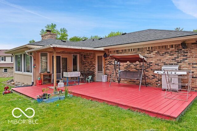 813 Boulder Rd, Indianapolis, IN 46217 - rear view of house with a wooden deck, a chimney, a lawn, and brick siding