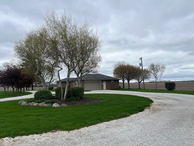 619 W 350 N, Covington, IN 47932 - view of front facade featuring curved driveway, an attached garage, a front yard, and brick siding