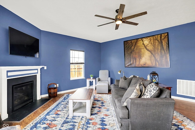 442 Mozart Dr, Greenfield, IN 46140 - living room with a ceiling fan, wood finished floors, baseboards, and a fireplace with flush hearth