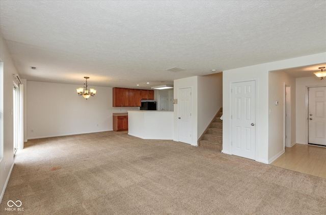 163 Clear Branch Dr, Brownsburg, IN 46112 - unfurnished living room with a chandelier, light carpet, baseboards, a textured ceiling, and recessed lighting