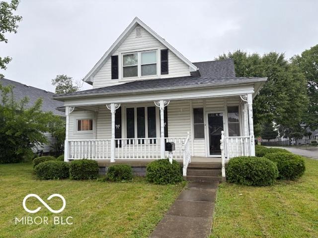 201 N 11th St, Elwood, IN 46036 - bungalow with covered porch, a front lawn, and a shingled roof