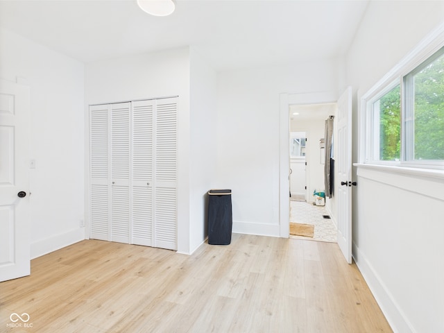 201 N 11th St, Elwood, IN 46036 - unfurnished bedroom with light wood-type flooring, a closet, baseboards, and ensuite bath