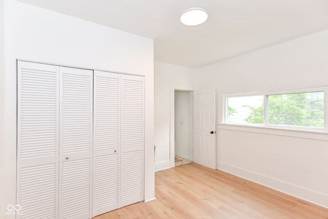 201 N 11th St, Elwood, IN 46036 - unfurnished bedroom featuring light wood finished floors, a closet, and baseboards