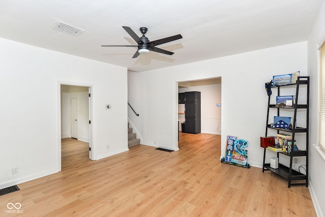 201 N 11th St, Elwood, IN 46036 - empty room featuring a ceiling fan, light wood finished floors, stairs, and baseboards